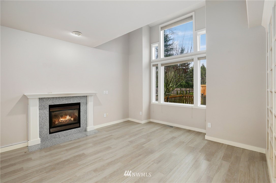 17539 110 Lane Southeast, Unit 20 Renton, WA 98055 - Photo 6 of 25 a view of an empty room with wooden floor fireplace and a window