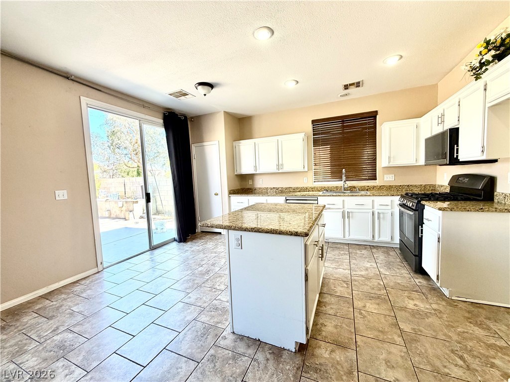3936 Gold Point Street Las Vegas, NV 89129 - Photo 3 of 23 A well-appointed kitchen features a central island and convenient patio access.