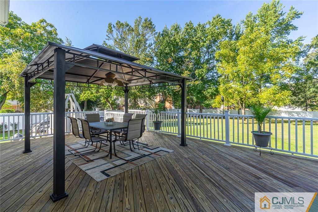 101 Aberdeen Road Aberdeen, NJ 07747 - Photo 4 of 21 a view of a patio with table and chairs under an umbrella with wooden floor