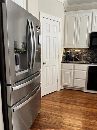 a kitchen with white cabinets and appliances