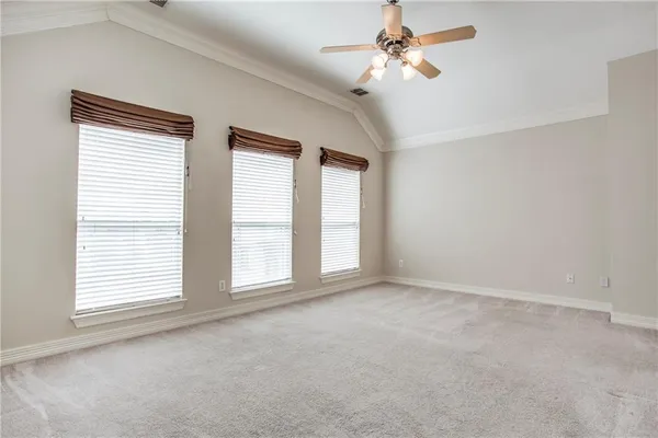 a view of an empty room with a chandelier fan
