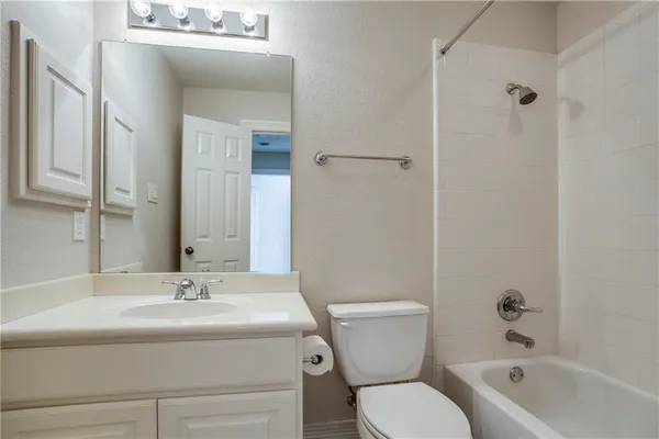 a view of an empty room with wooden floor fireplace and a window