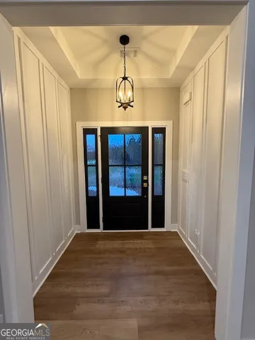 a view of a hallway with wooden floor and windows