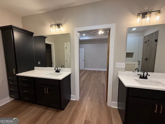 a bathroom with a sink vanity granite tub and a mirror