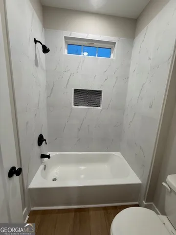 a bathroom with a bathtub and a shower