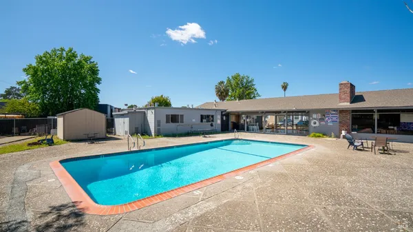 a view of a house with swimming pool and sitting area