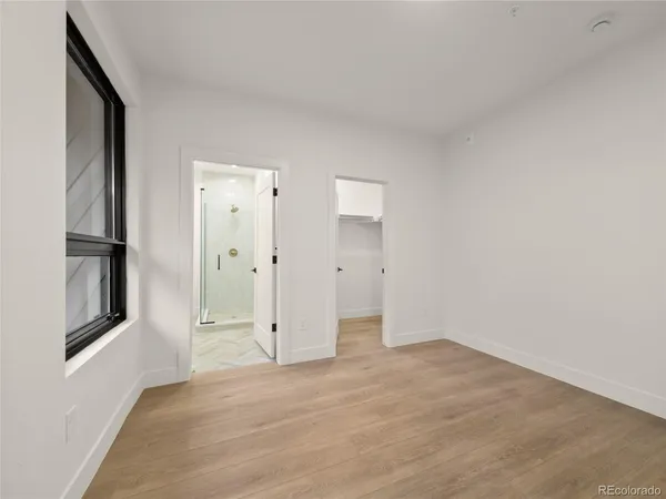 a view of empty room with wooden floor and window