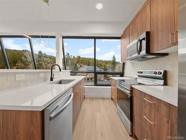 a kitchen with stainless steel appliances granite countertop a sink and a stove