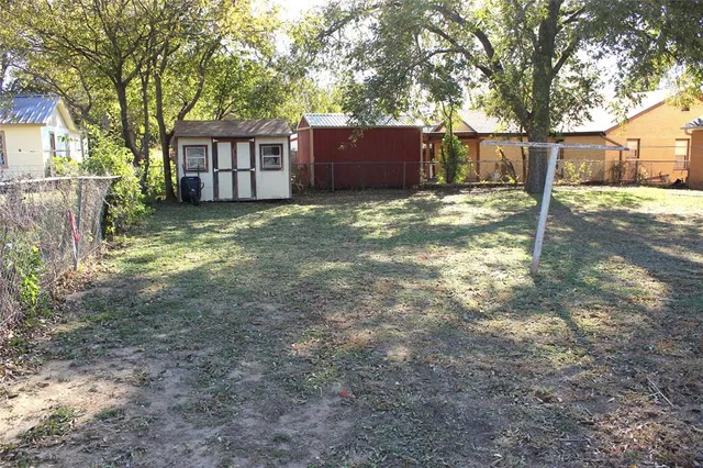 a view of a house with backyard and tree
