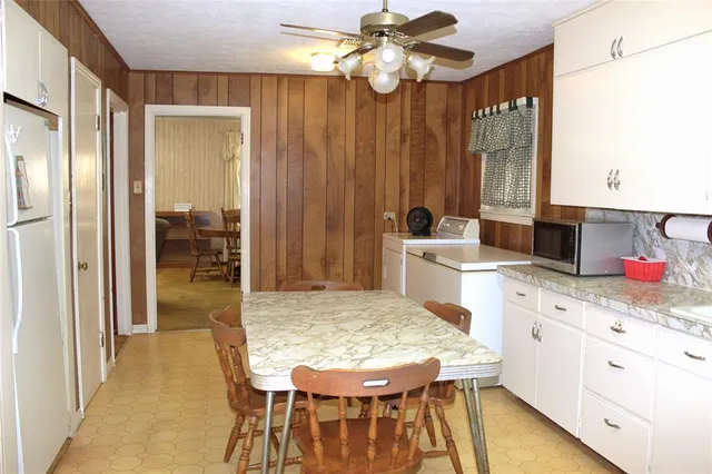 a kitchen with a table chairs and a refrigerator
