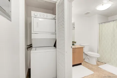 a bathroom with a granite countertop sink and a toilet
