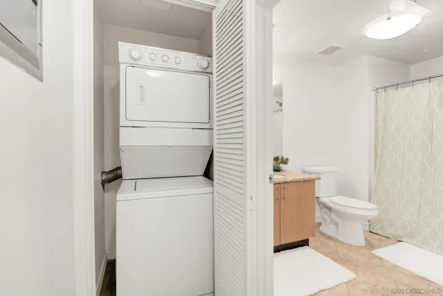 a bathroom with a granite countertop sink and a toilet