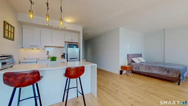 a very nice looking room with kitchen view and a chair