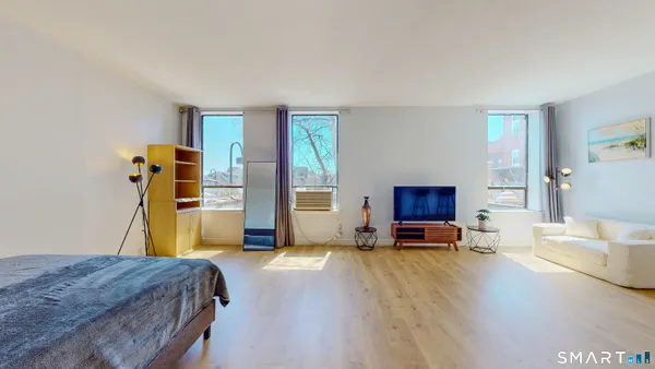 a bedroom with a bed and wooden floor