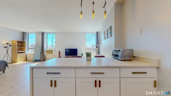 a view of kitchen with sink stainless steel appliances and living room