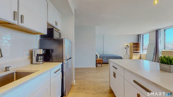 a view of kitchen with sink stainless steel appliances and cabinets