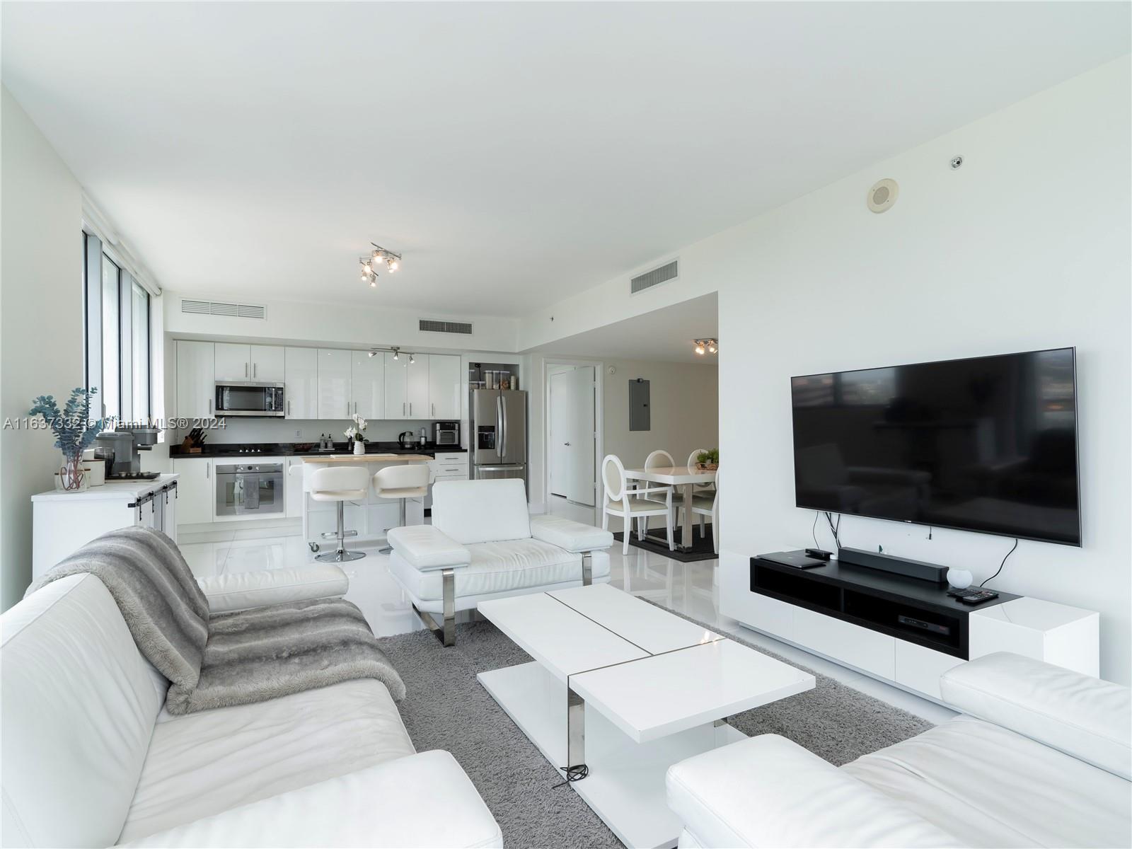 92 Southwest 3rd Street, Unit 1505 Miami, FL 33130 - Photo 11 of 37 a living room with furniture and a flat screen tv