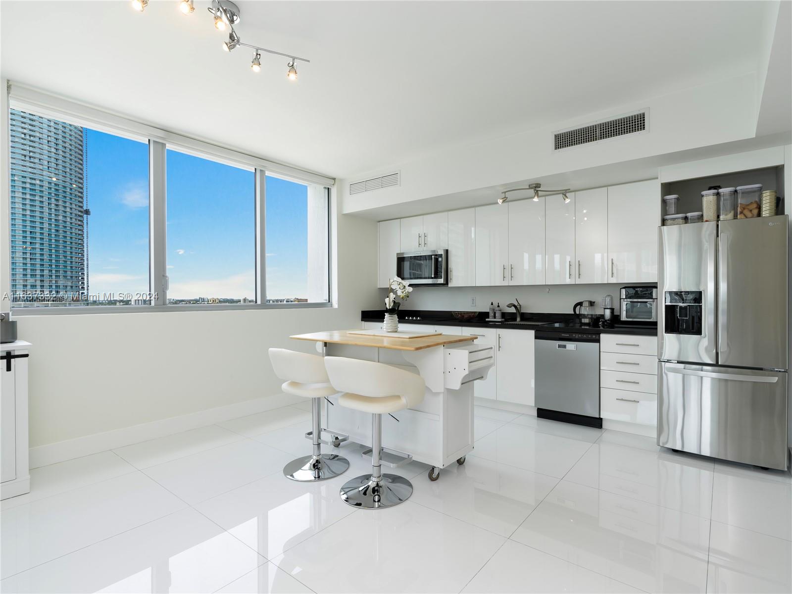 92 Southwest 3rd Street, Unit 1505 Miami, FL 33130 - Photo 12 of 37 a kitchen with a sink cabinets and stainless steel appliances
