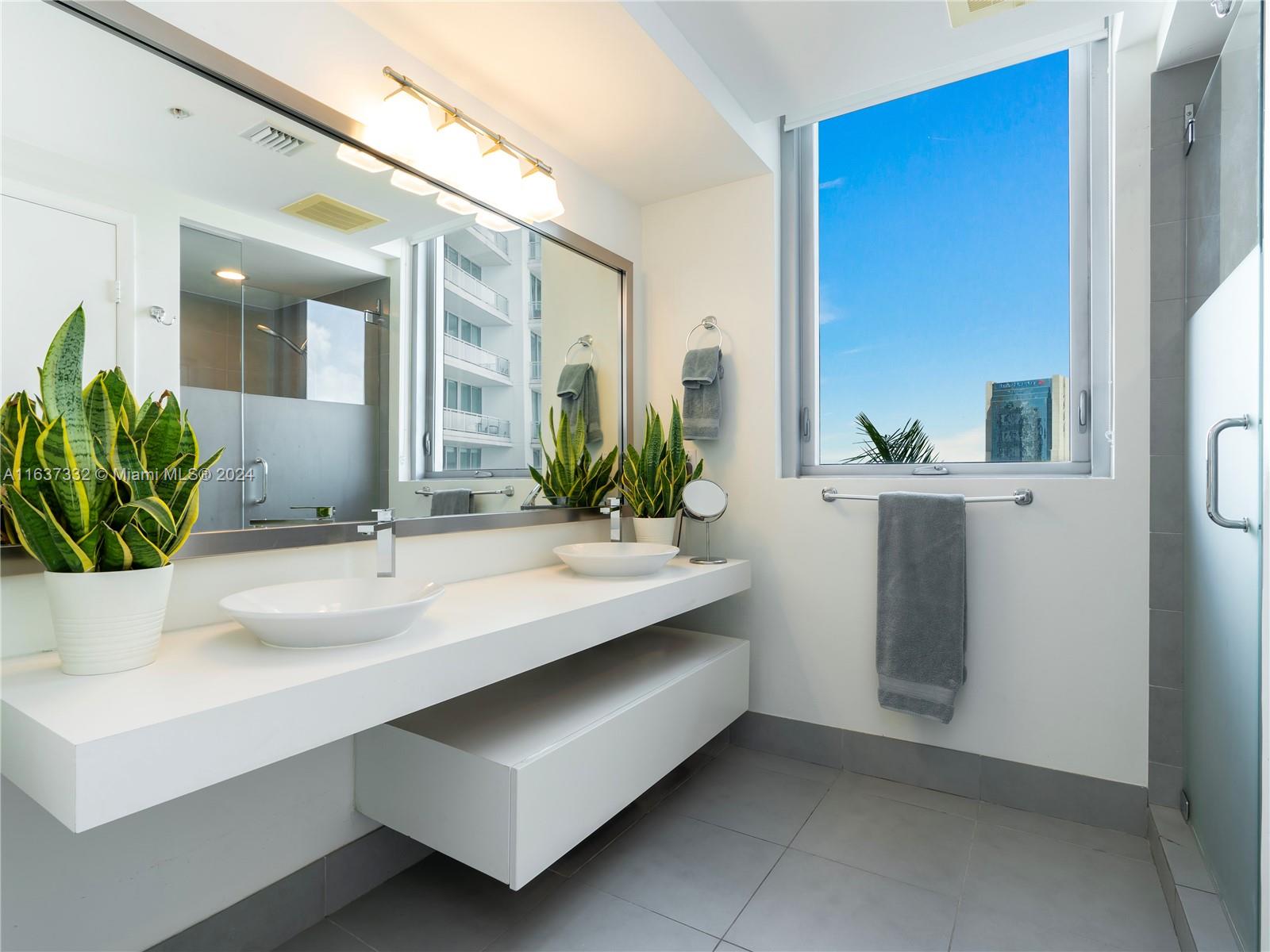 92 Southwest 3rd Street, Unit 1505 Miami, FL 33130 - Photo 20 of 37 a bathroom with a sink and a mirror