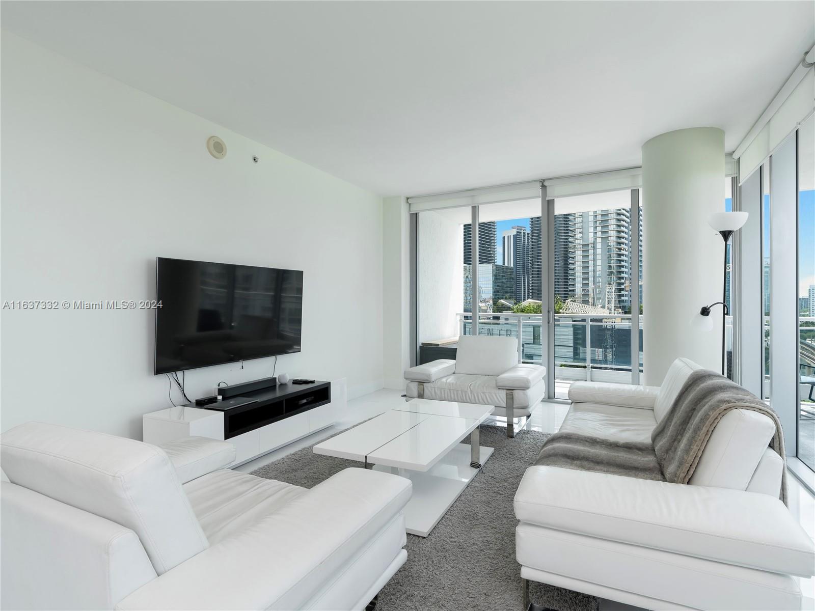 92 Southwest 3rd Street, Unit 1505 Miami, FL 33130 - Photo 10 of 37 a living room with furniture and a flat screen tv