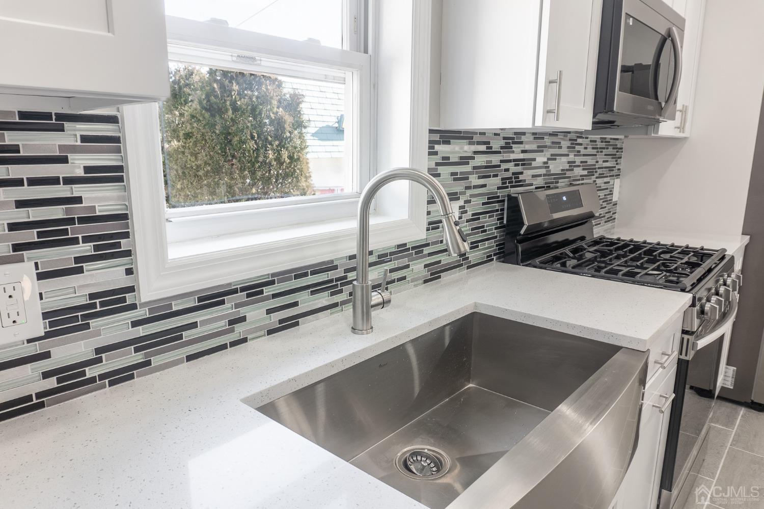 420 Crows Mill Road Fords, NJ 08863 - Photo 4 of 38 a kitchen with a sink and a stove next to a window