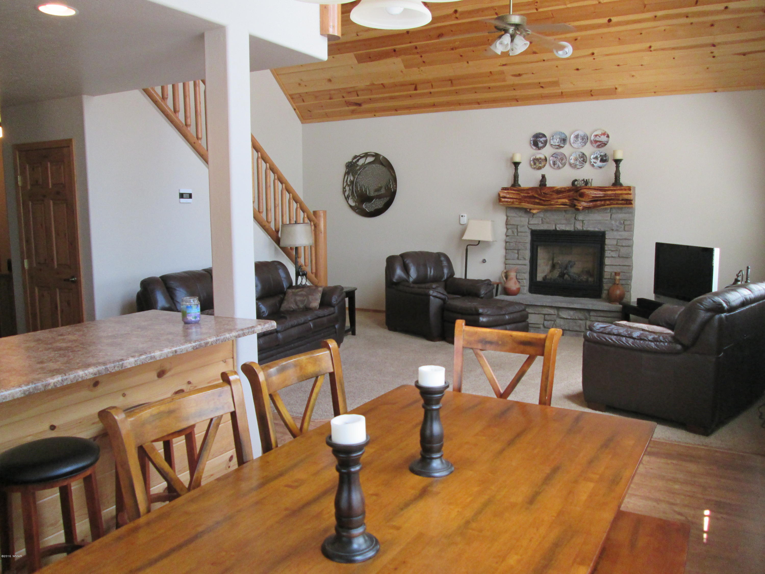 3048 Aspen Road Overgaard, AZ 85933 - Photo 15 of 36 a living room with furniture a fireplace and a flat screen tv