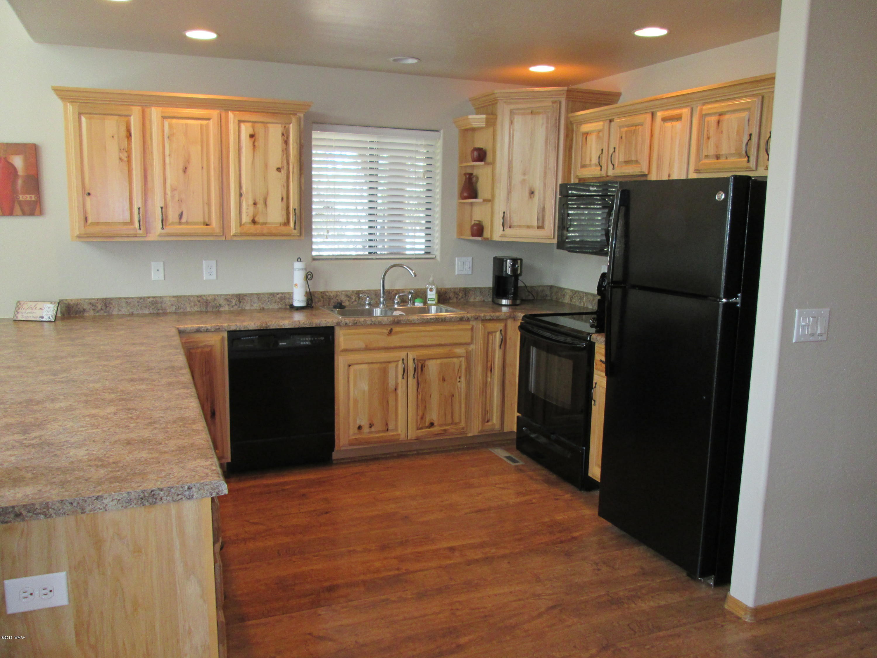 3048 Aspen Road Overgaard, AZ 85933 - Photo 18 of 36 a kitchen with stainless steel appliances granite countertop a refrigerator a sink a stove and dishwasher with wooden cabinets