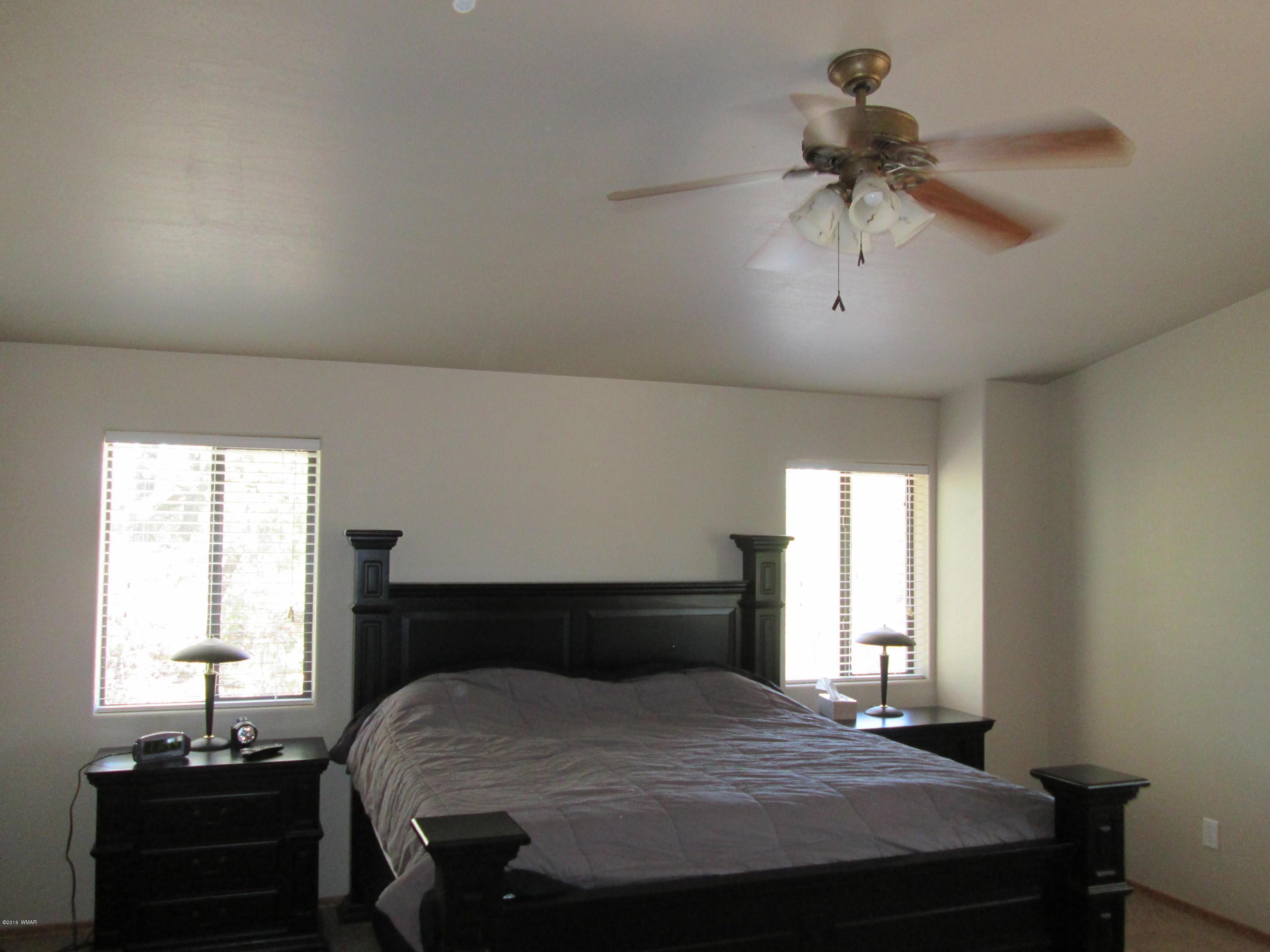 3048 Aspen Road Overgaard, AZ 85933 - Photo 22 of 36 a bedroom with a bed and wooden floor