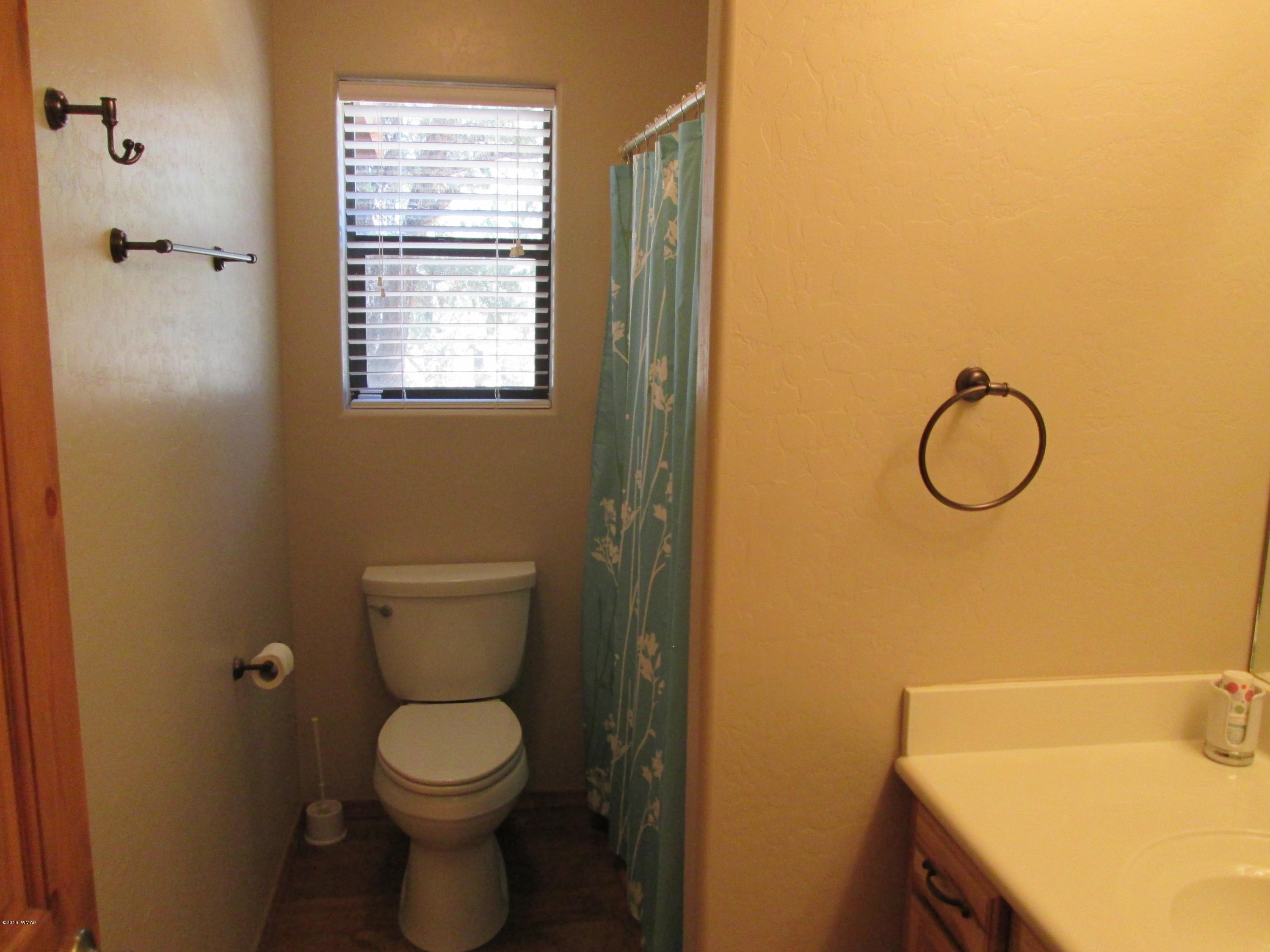 3048 Aspen Road Overgaard, AZ 85933 - Photo 27 of 36 a bathroom with a granite countertop toilet and a sink