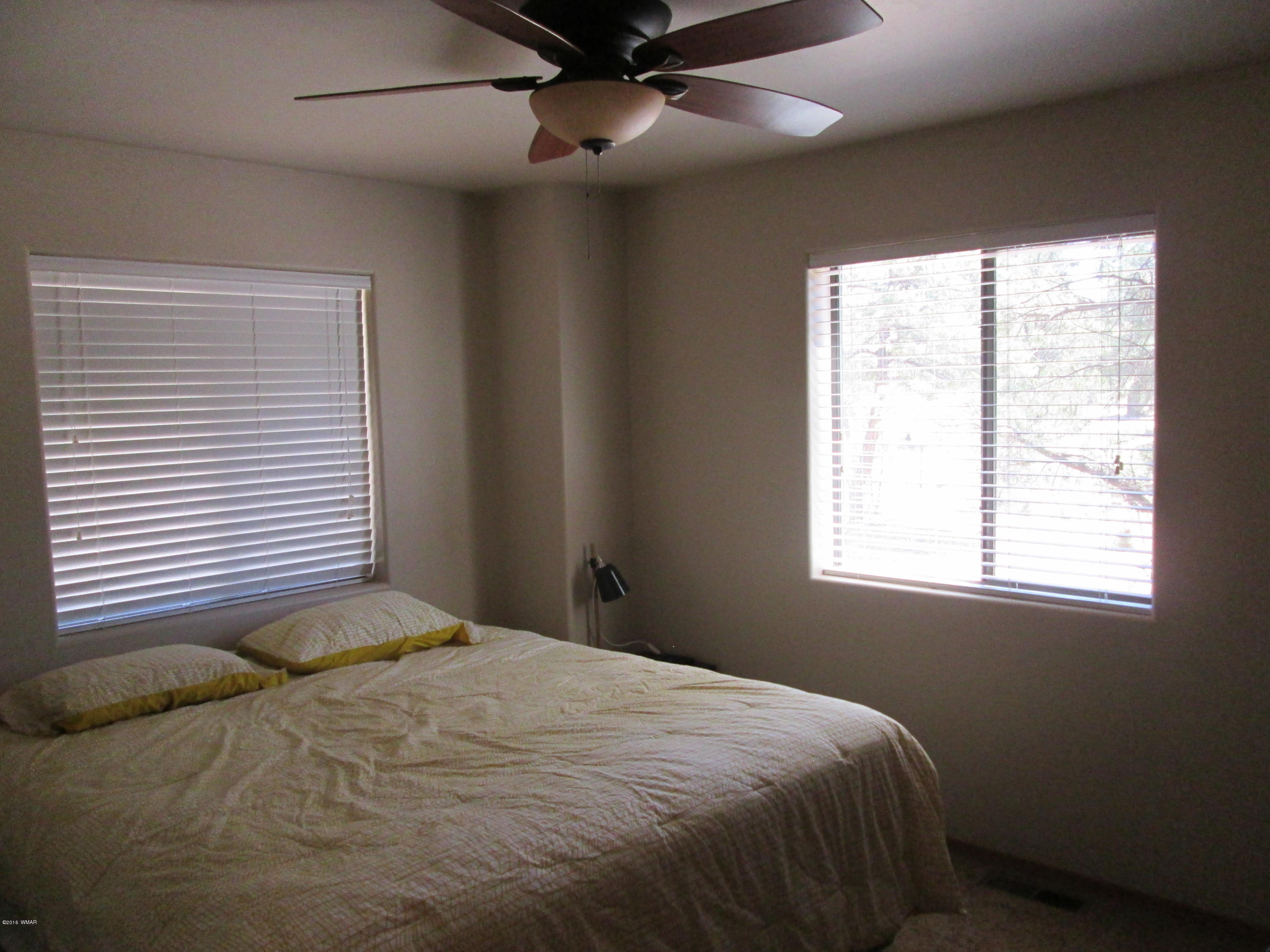 3048 Aspen Road Overgaard, AZ 85933 - Photo 29 of 36 a bedroom with a bed and a window