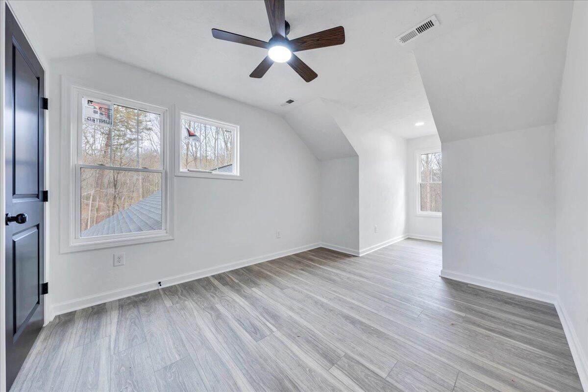 610 Gap Bridge Road Moneta, VA 24121 - Photo 18 of 62 an empty room with wooden floor chandelier fan and windows