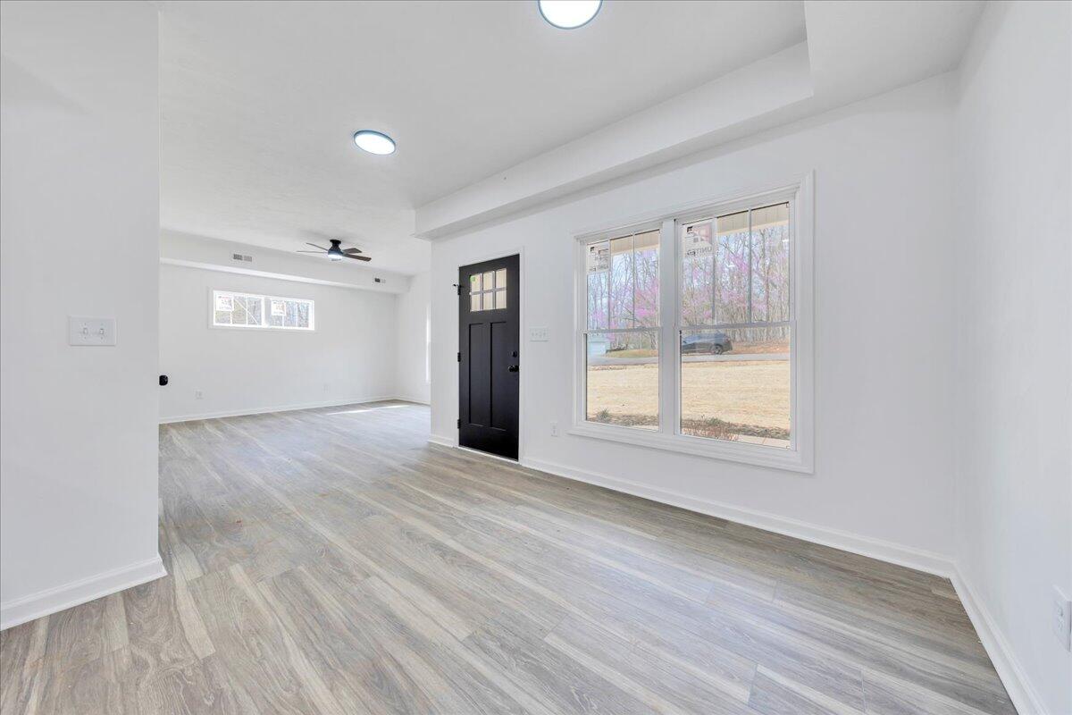 610 Gap Bridge Road Moneta, VA 24121 - Photo 5 of 62 an empty room with wooden floor and windows