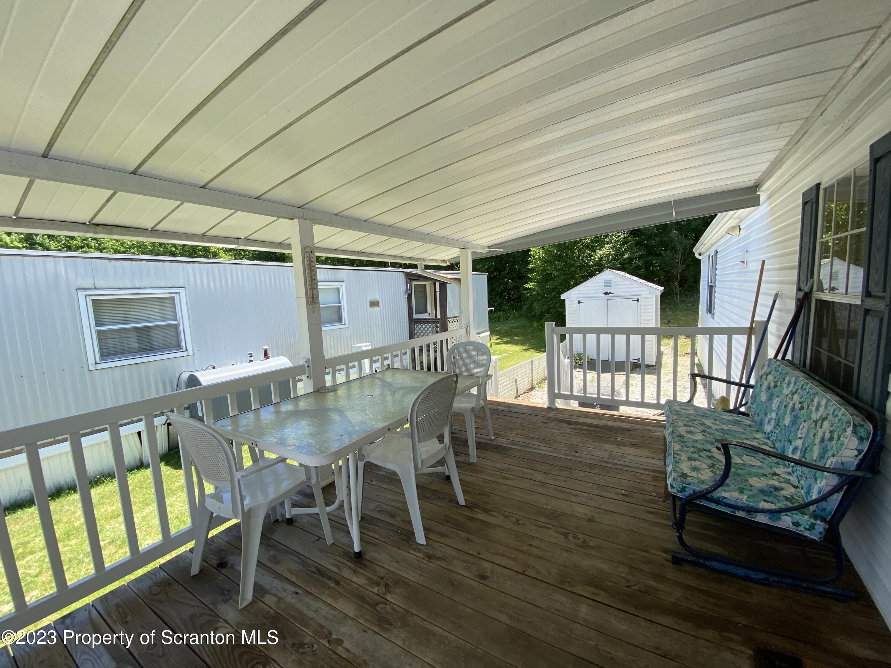 4 Honor Park Moosic, PA 18507 - Photo 2 of 24 a view of a patio with table and chairs with wooden floor and fence