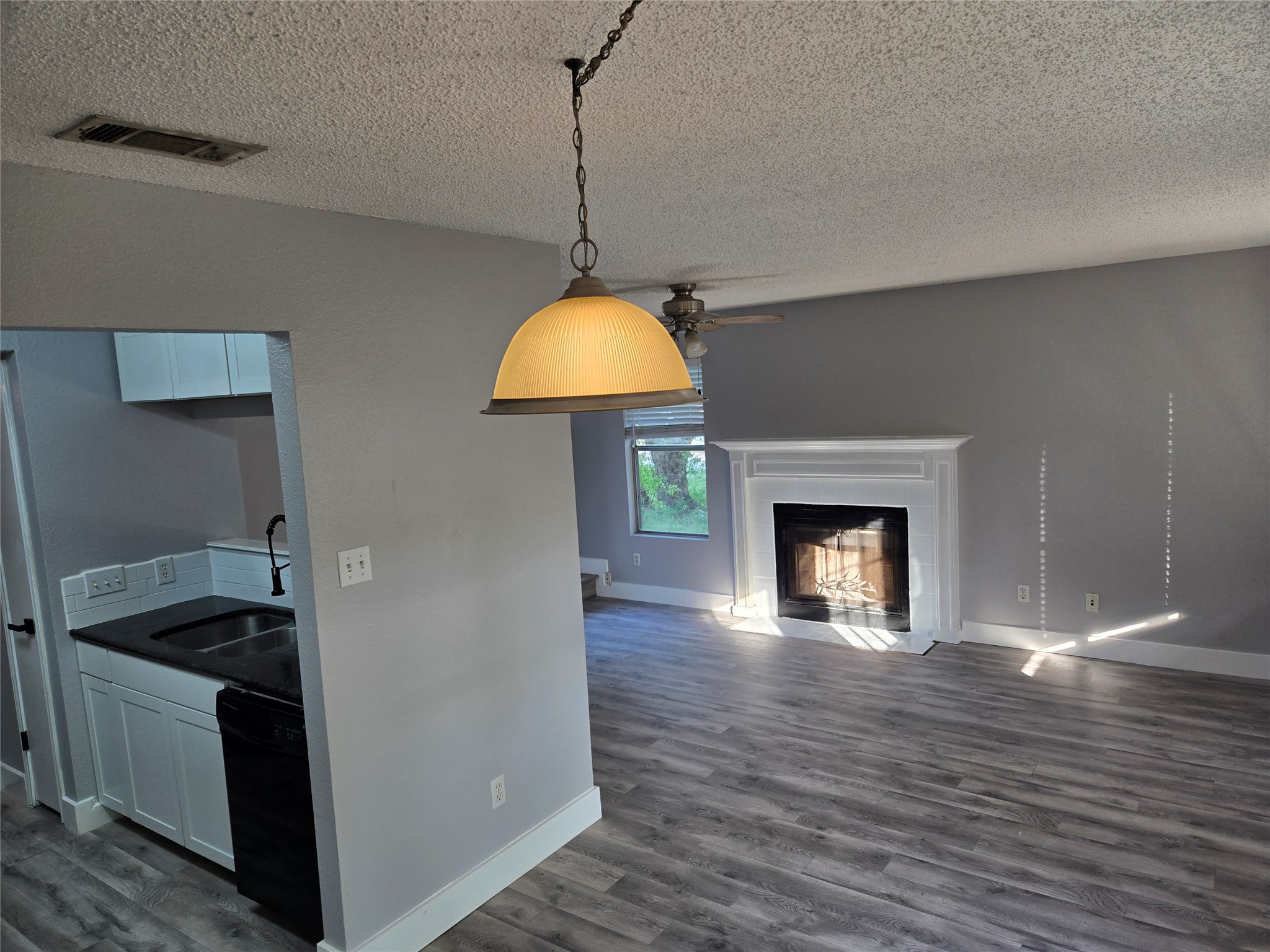 a view of empty room with wooden floor and fireplace