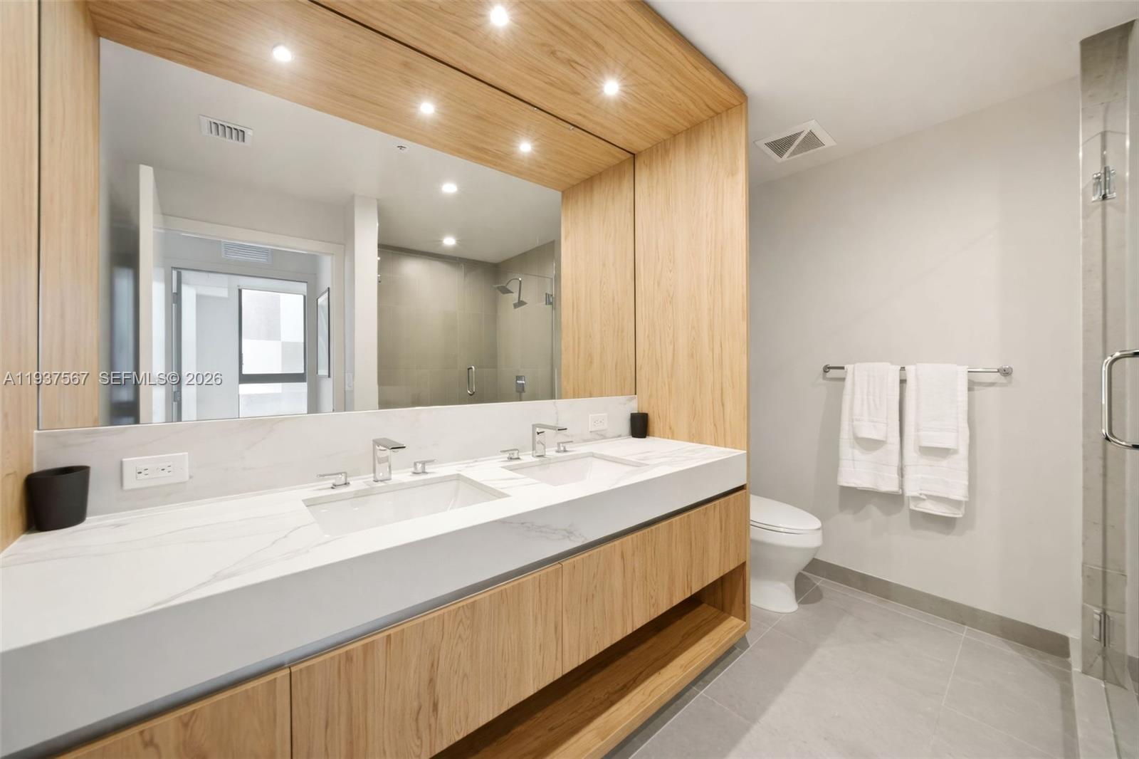 11 Northeast 6th Street, Unit 709 Miami, FL 33132 - Photo 14 of 54 a spacious bathroom with a double vanity sink mirror and toilet