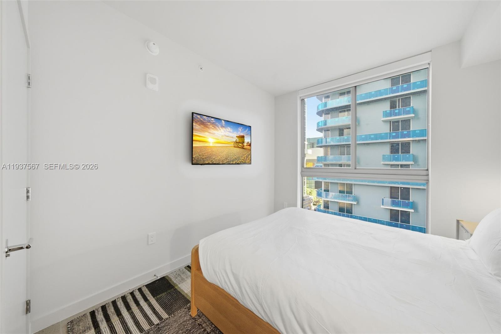 11 Northeast 6th Street, Unit 709 Miami, FL 33132 - Photo 18 of 54 a bedroom with a bed and a bookshelf
