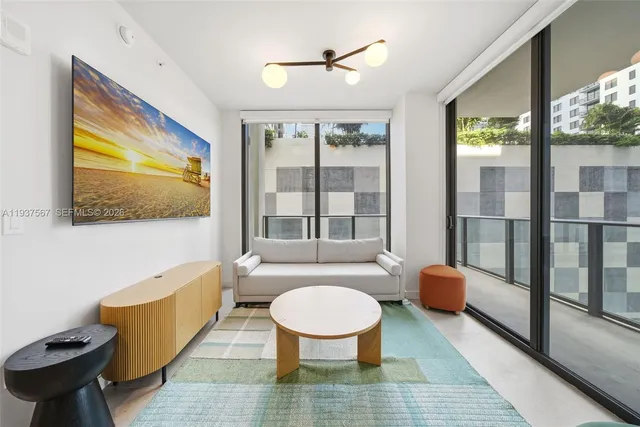 a living room with furniture a large window and wooden floor