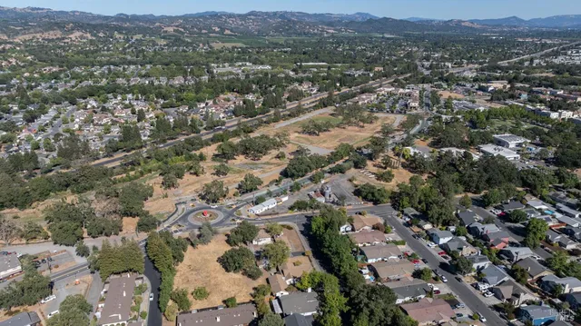 an aerial view of residential houses with outdoor space and trees