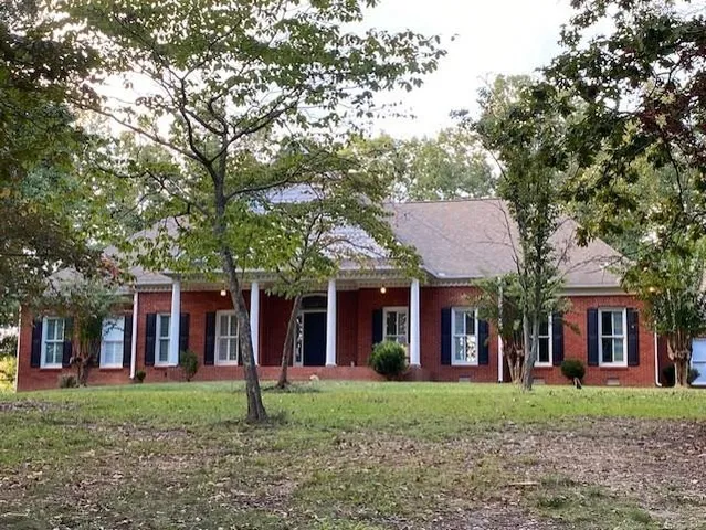 front view of a brick house with a yard