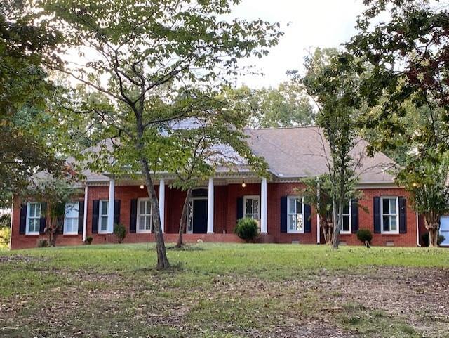 front view of a brick house with a yard
