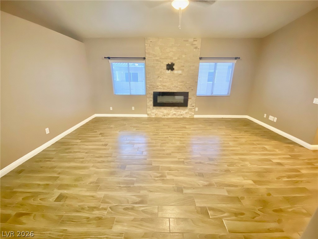 2000 Turquoise Ridge Street, Unit 204 Las Vegas, NV 89117 - Photo 11 of 29 A well-lit living area features wood-look tile flooring and a sleek fireplace with a stone surround.