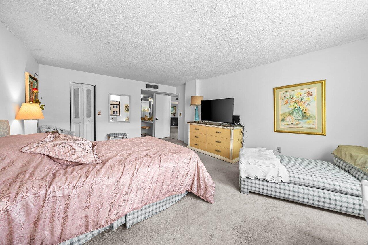3460 South Ocean Boulevard, Unit 6150 Palm Beach, FL 33480 - Photo 13 of 34 a bedroom with a bed and wooden floor