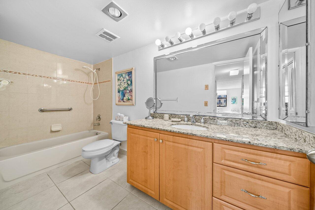 3460 South Ocean Boulevard, Unit 6150 Palm Beach, FL 33480 - Photo 15 of 34 a bathroom with a granite countertop sink toilet mirror and bathtub
