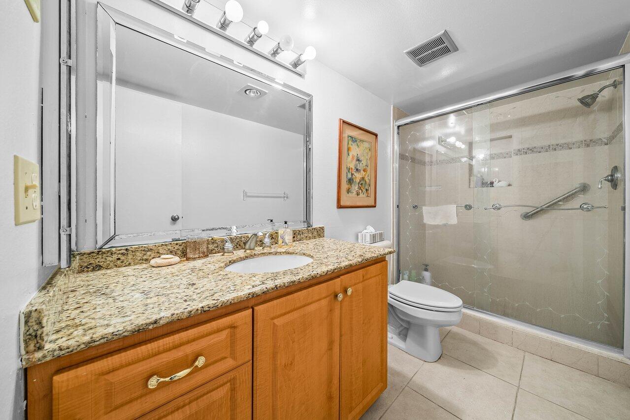 3460 South Ocean Boulevard, Unit 6150 Palm Beach, FL 33480 - Photo 18 of 34 a bathroom with a granite countertop sink toilet and shower