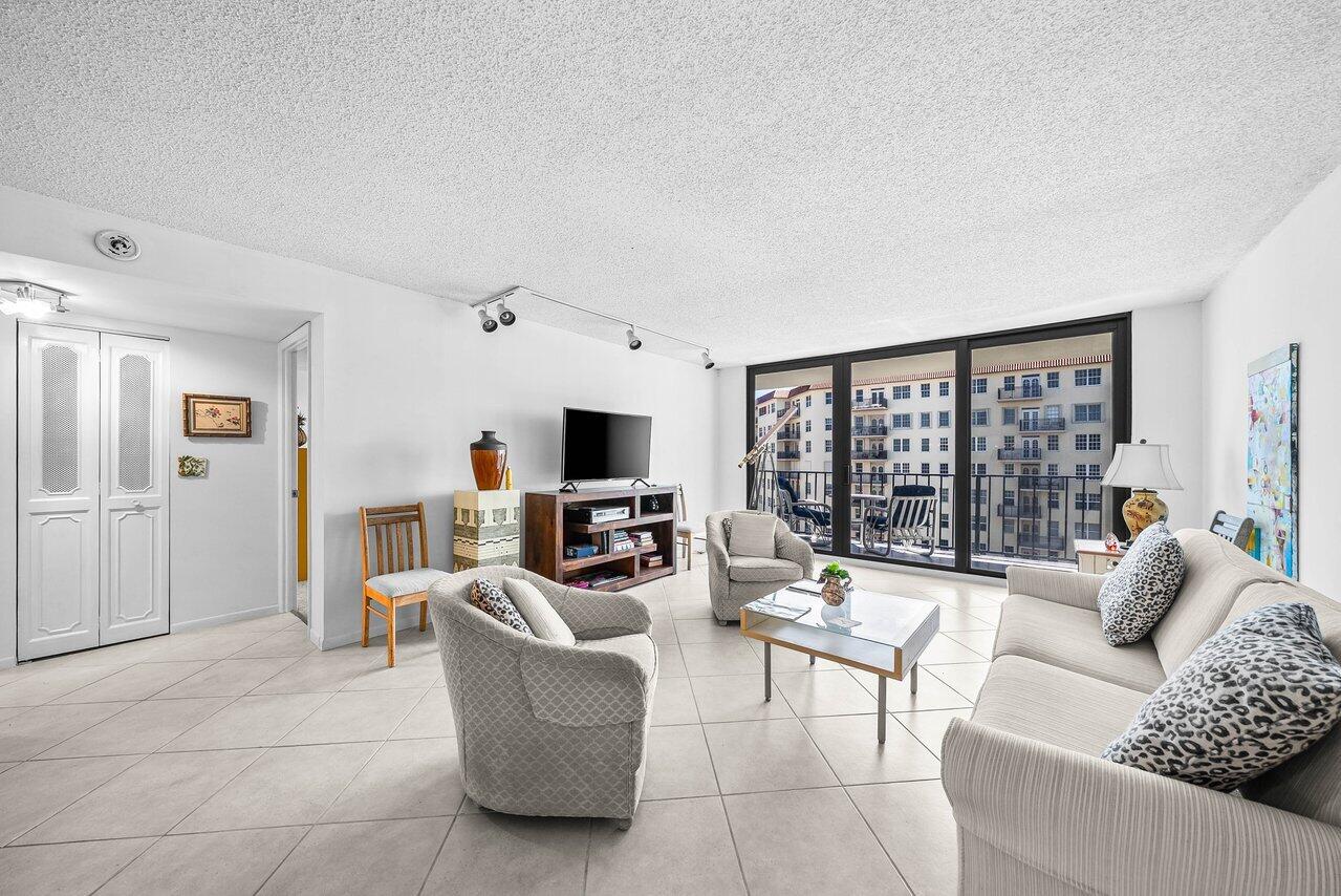 3460 South Ocean Boulevard, Unit 6150 Palm Beach, FL 33480 - Photo 6 of 34 a living room with furniture a flat screen tv and a large window