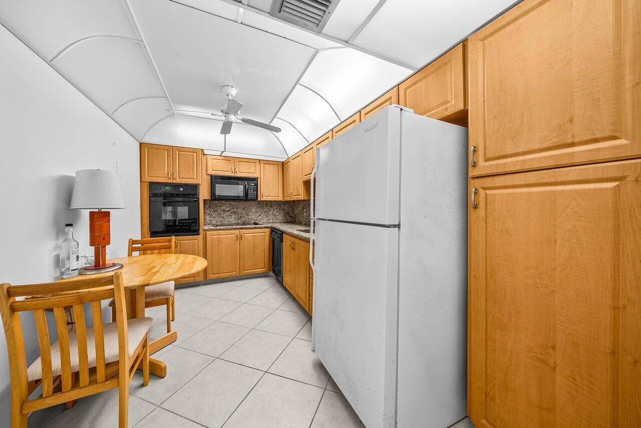 3460 South Ocean Boulevard, Unit 6150 Palm Beach, FL 33480 - Photo 9 of 34 a kitchen with stainless steel appliances granite countertop a refrigerator and a sink