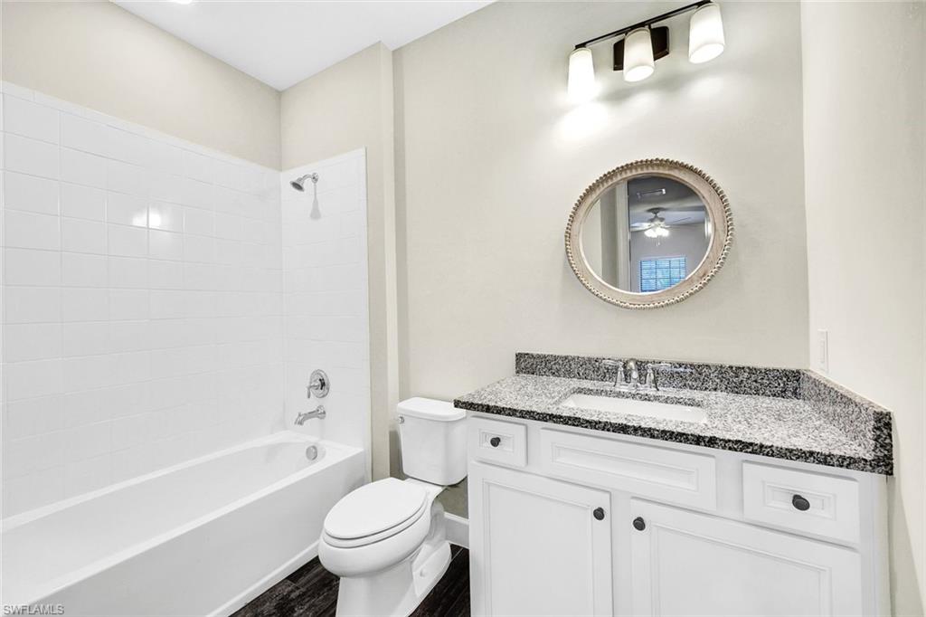 19176 Elston Way Estero, FL 33928 - Photo 17 of 26 a bathroom with a granite countertop toilet sink and mirror