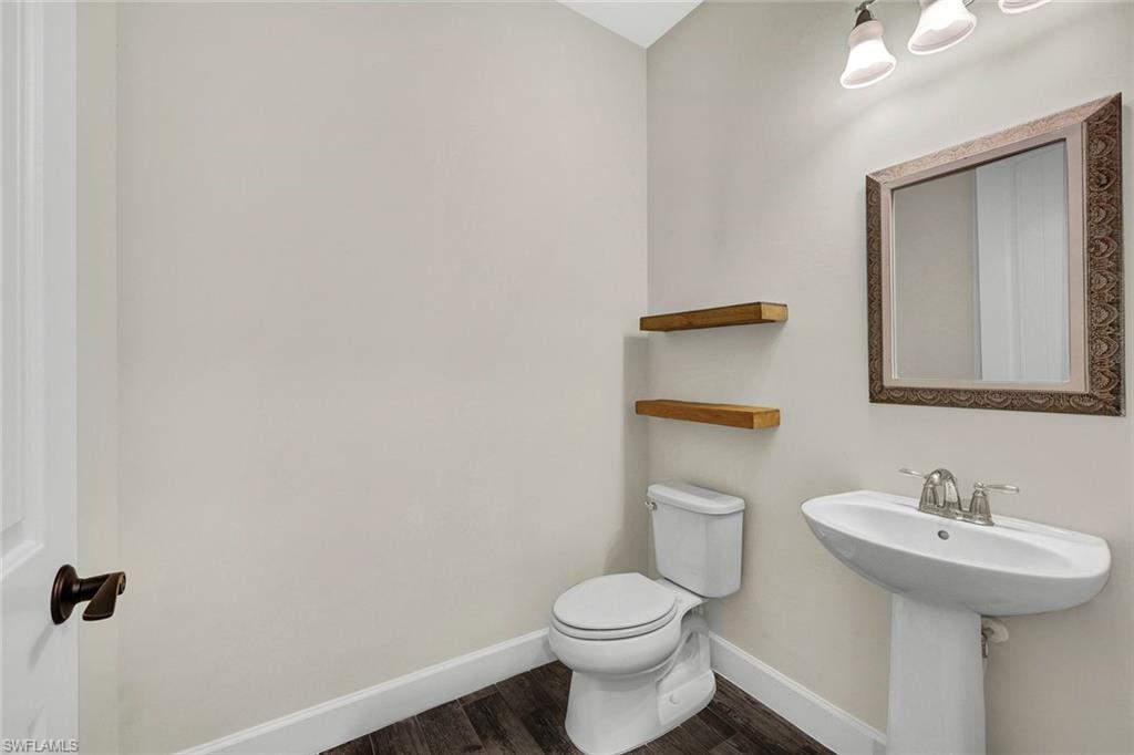 19176 Elston Way Estero, FL 33928 - Photo 21 of 26 a bathroom with a sink a toilet and mirror
