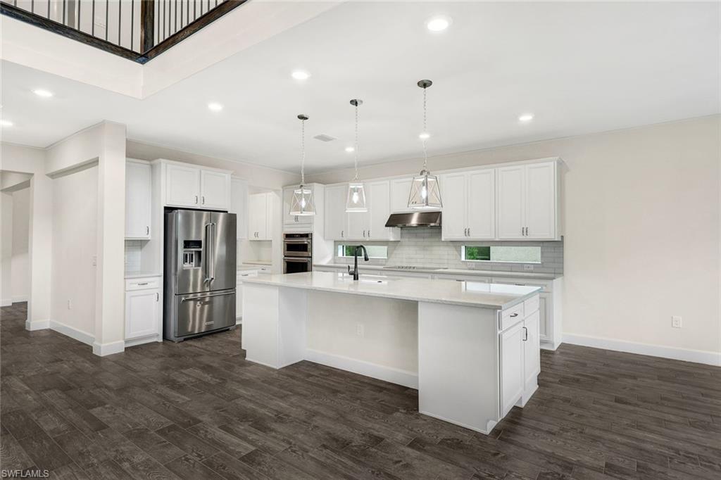19176 Elston Way Estero, FL 33928 - Photo 6 of 26 a kitchen with stainless steel appliances granite countertop a refrigerator a sink dishwasher a stove and white cabinets with wooden floor