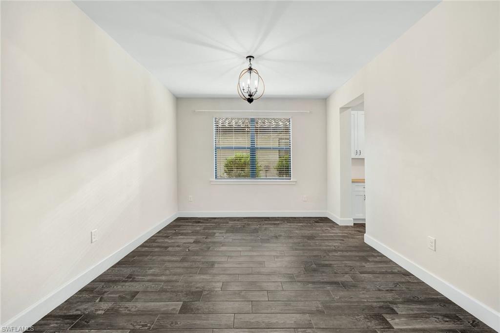 19176 Elston Way Estero, FL 33928 - Photo 9 of 26 an empty room with wooden floor chandelier fan and windows